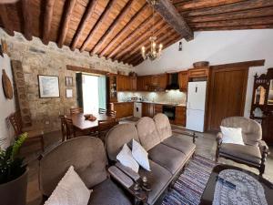 uma sala de estar com um sofá e cadeiras e uma cozinha em King's house em Lofou