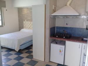 1 dormitorio pequeño con 1 cama y cocina en Departamentos Colón depto 1 en Carhué
