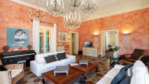 a living room with a white couch and a piano at VILLA CORALLINA 12, Emma Villas in Marina di Bibbona