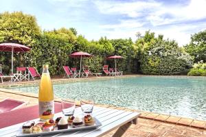 a table with food and a bottle of wine next to a swimming pool at Foresteria Il Giardino di Fontarronco in Alberoro