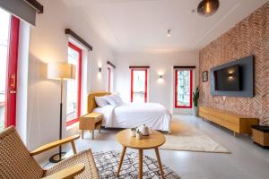 Habitación de hotel con cama y TV en Leiden Homestay&Cafe' en Ho Chi Minh