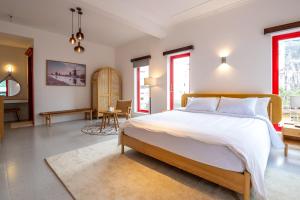 a bedroom with a large bed and a living room at Leiden Homestay&Cafe' in Ho Chi Minh City
