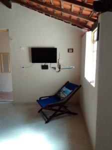 een blauwe stoel in een kamer met een flatscreen-tv bij Casa Colonial no Centro in Carolina