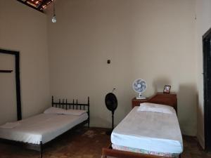 a room with two beds and a fan in it at Casa Colonial no Centro in Carolina