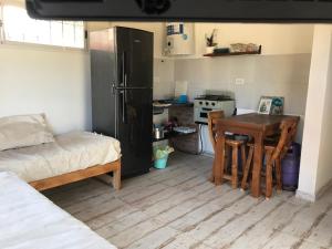 a small kitchen with a table and a refrigerator at India del mar II in Chapadmalal