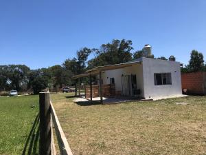 a small white building in a field with a fence at India del mar II in Chapadmalal +3 photos