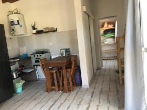 a kitchen with a table and chairs and an open refrigerator at India del mar II in Chapadmalal