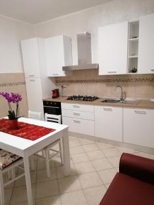 a kitchen with white cabinets and a white table at IN CENTRO in Porto SantʼElpidio