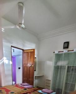 Habitación con cama, puerta y espejo. en Busy Bee Apartments en Kololi