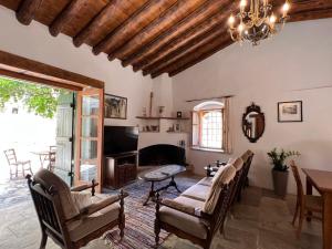 a living room with a fireplace and a table and chairs at King's house in Lofou