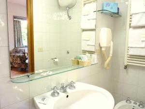 ein Badezimmer mit einem Waschbecken, einem Spiegel und Handtüchern in der Unterkunft Classic Hotel in Florenz