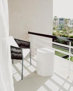 a balcony with a chair and a table at BirdNest at Sheikh Zayed in Sheikh Zayed