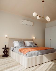 a bedroom with a large bed with an orange blanket at BIRD NEST at Sheikh Zayed in Sheikh Zayed