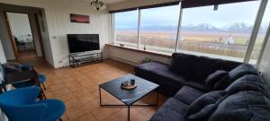 a living room with a couch and a flat screen tv at Hátún in Glaumbær