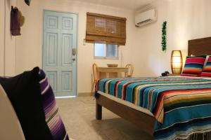 1 dormitorio con 1 cama y puerta azul en Hotel Villas Colibrí Suites & Bungalows, en Cozumel