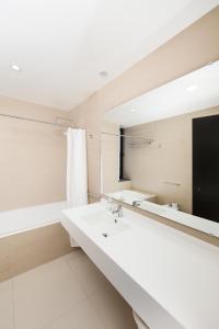 a bathroom with two sinks and a mirror at XA Apartments RRAL-579 in Madalena