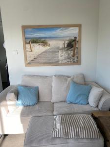 a living room with a couch and a painting on the wall at Seaside Beach House Chalet - Seeparx Süsel in Süsel