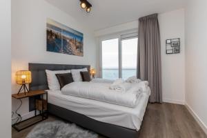 een slaapkamer met een groot bed en een groot raam bij Appartement Vista Maris, Havenweg 8-1, St. Annaland in Sint Annaland