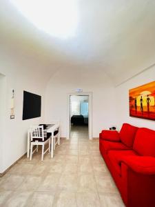 uma sala de estar com um sofá vermelho e uma mesa em Casa Aurora em Bari