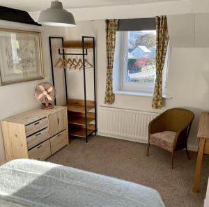 a bedroom with a bed and a chair and a window at Taylor Way in Aberystwyth