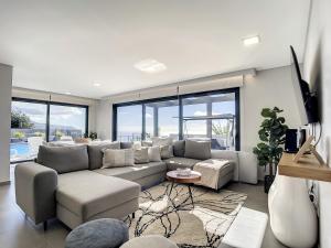 a living room with a couch and a table at Villa de la Ponte by Atlantic Holiday in Arco da Calheta