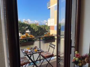 un tavolo e sedie su un balcone con vista di Lady House a Reggio di Calabria