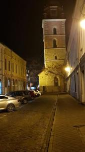 un edificio con una torre de reloj en una calle por la noche en Komfortowy apartament w centrum Nowego Sącza en Nowy Sącz