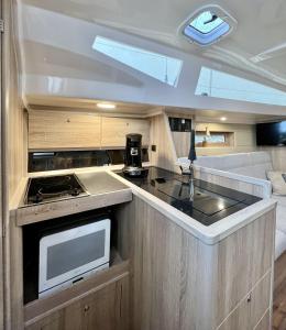 an rv kitchen with a sink and a microwave at Hausboot Segelyacht Nui in Burgtiefe auf Fehmarn 