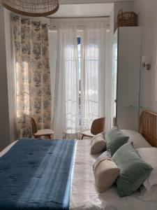 Un dormitorio con una cama grande con almohadas. en Hôtel Eden - La Baigneuse, en Juan-les-Pins
