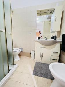 uma casa de banho com um lavatório, um WC e um espelho. em Casa Aurora em Bari