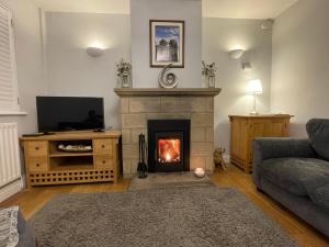 a living room with a fireplace and a couch at Cathedral View in Tideswell