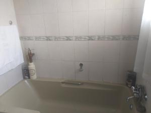 een badkamer met een groen bad met een kraan bij Feel at home stay in Bloemfontein
