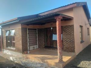 een stenen huis met een veranda en een paal bij Feel at home stay in Bloemfontein