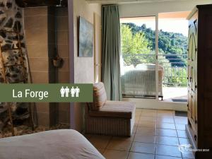 a bedroom with a bed and a chair and a balcony at Pyrénées Mon Amour in Felluns