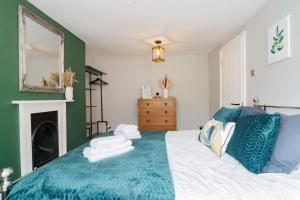 een groene en witte slaapkamer met een bed en een open haard bij Stunning 3 bed Home, 5 mins from Margate Beach in Kent