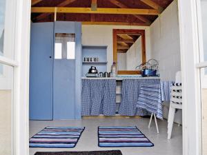 a kitchen with blue walls and a kitchen with mats on the floor at Roosters - E4864 in Chapel Saint Leonards