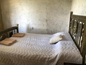 a bed with white sheets and pillows on it at Matices de Molinos Hostal in Molinos