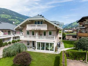 uma vista exterior de uma casa de hóspedes com montanhas ao fundo em Gästehaus Wiesengrund & Apart Sporer em Mayrhofen