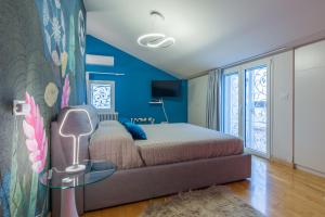 - une chambre avec un lit et un mur bleu dans l'établissement Villa Fai Bei Sogni-Green Bed & Breakfast, à Coriano
