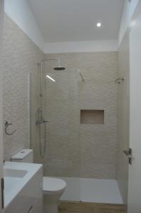 een badkamer met een douche, toilet en wastafel bij Quinta das Figueiras in Vila Nova de Cacela +31 foto's