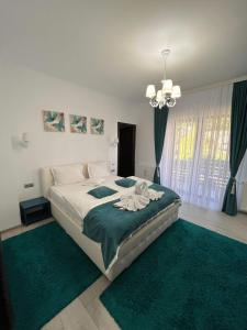 a bedroom with a large bed with green carpet at Casa Hera in Sinaia
