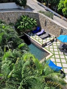 een zwembad met stoelen, parasols en palmbomen bij OASIS 1 Bedroom Apartment Simpson Bay in Simpson Bay