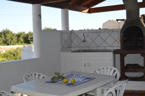 een witte keuken met een tafel en stoelen en een fornuis bij Quinta das Figueiras in Vila Nova de Cacela