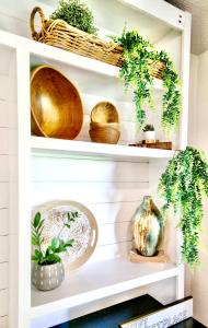a white shelf with bowls and plants on it at Modern Boho Retreat in Corvallis