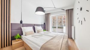 a bedroom with a large bed with a purple headboard at Rybacka Kołobrzeg in Kołobrzeg