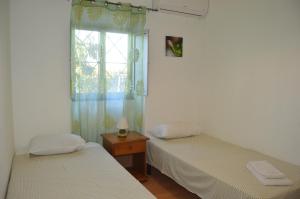 Duas camas num quarto com uma janela em Quinta das Figueiras em Vila Nova de Cacela