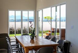 a dining room with a table and chairs and windows at Pousada Vila Craton Canastra in São João Batista do Glória