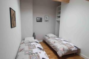 two beds in a room with white walls at Sweet LOFT A PERIGNAT !!! in Pérignat-sur-Allier