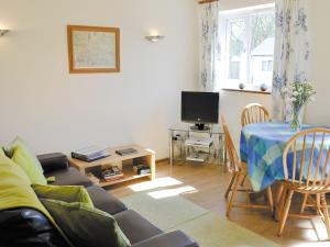 a living room with a couch and a table at Rose Cottage in Winterborne Steepleton