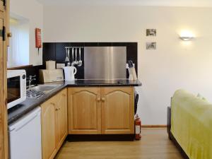a kitchen with a sink and a microwave at Rose Cottage in Winterborne Steepleton